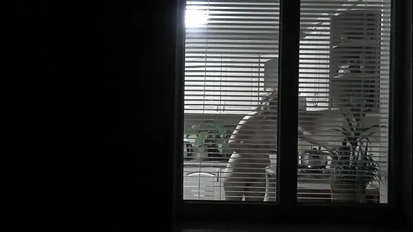 XXX Peeping. Voyeur. Neighbor pervert voyeur in evening on street looks out window as naked sexy neighbor in kitchen prepares dinner for her husband. Naked in public. Naked at home. Family. Outdoor mega Movies